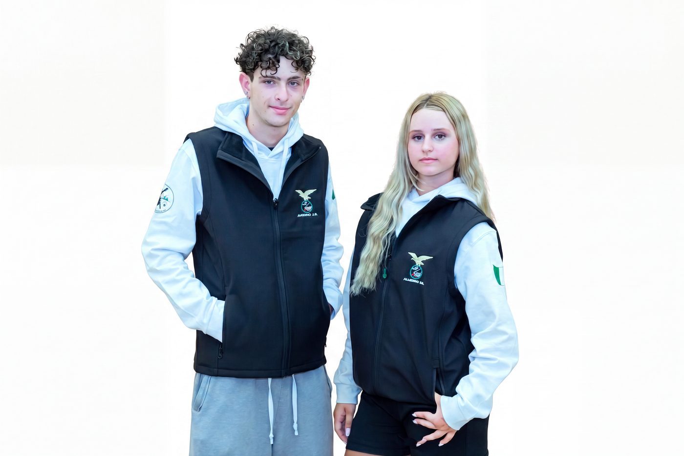 Coppia di ragazzi con gilet nero con zip indossato sopra la felpa bianca con cappuccio