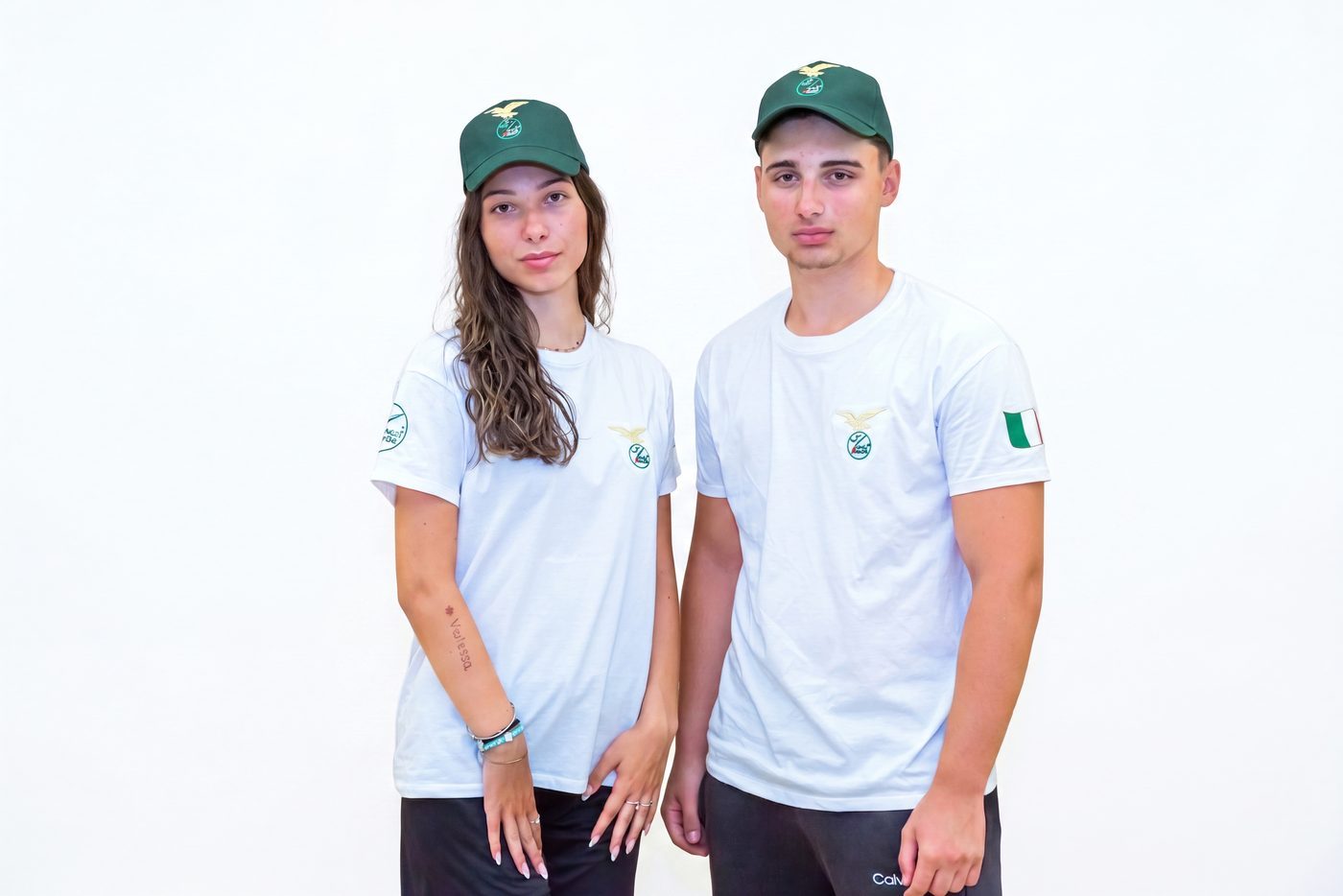 Maglietta bianca del Campo Scuola indossata da una ragazza e un ragazzo, con cappellino verde
