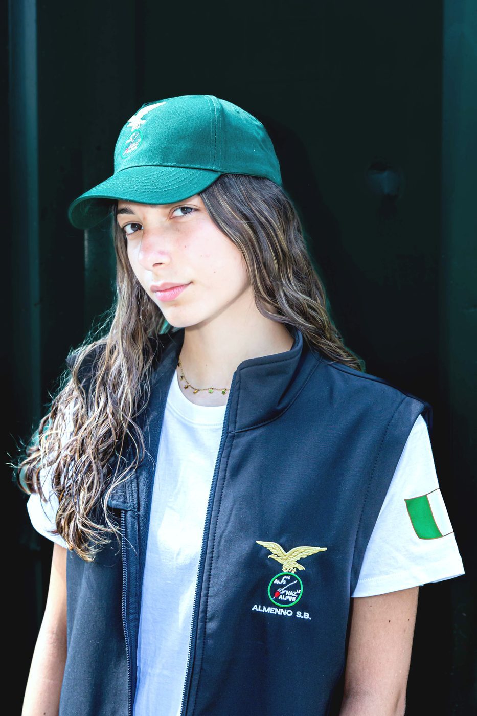 Ragazza con gilet nero ricamato ANA Almenno S.B. e cappellino verde