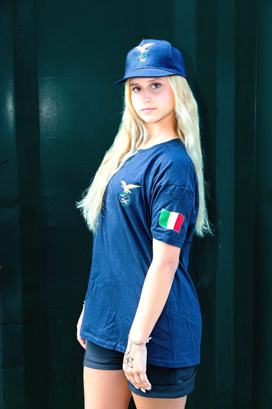 Vista laterale della maglietta blu con patch tricolore sulla manica