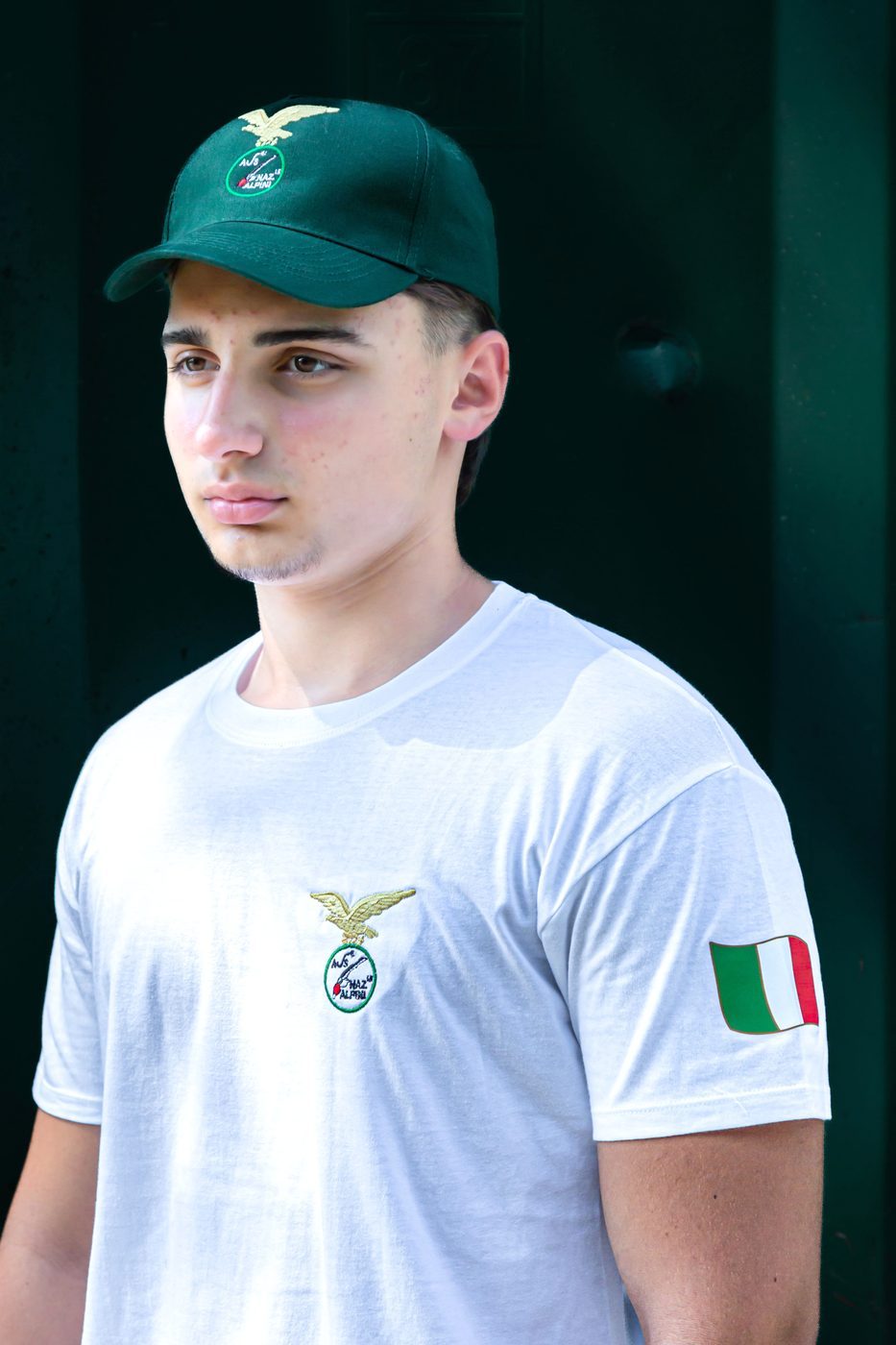 Ragazzo di tre quarti: logo ricamato sul petto e bandiera italiana sulla manica