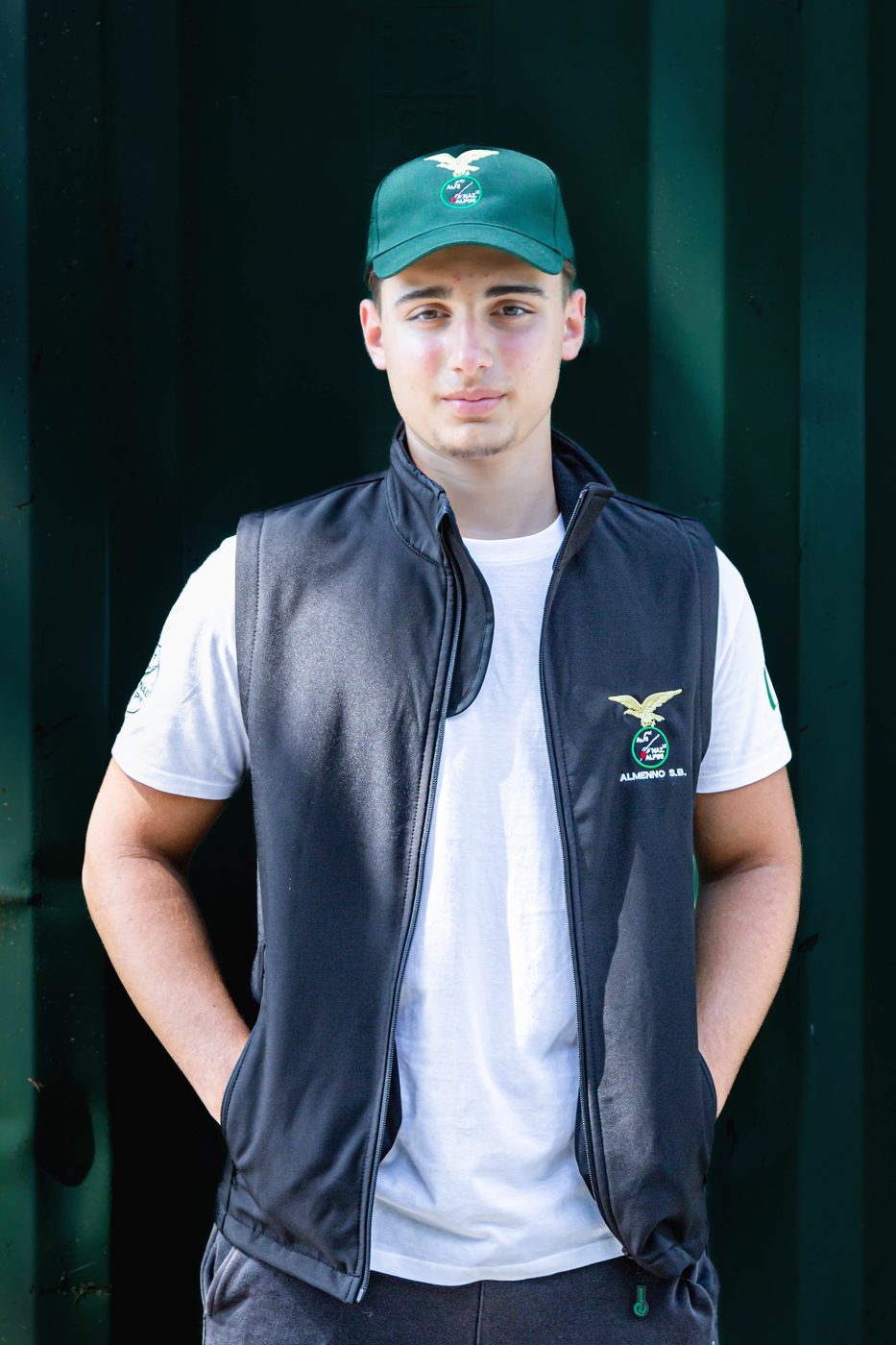 Capisquadra con gilet nero ricamato Almenno S.B. su maglietta bianca e cappellino verde