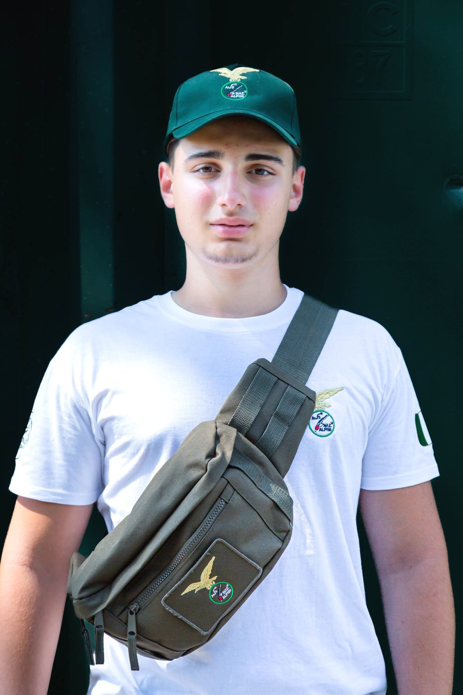 Capisquadra con marsupio verde militare a tracolla, maglietta bianca e cappellino verde