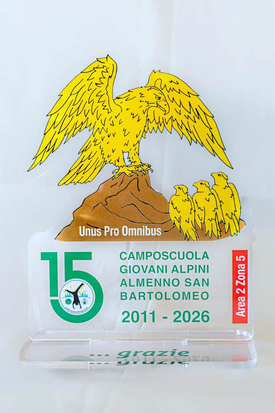 Targhetta in plexiglass con aquila dorata Unus Pro Omnibus, 15° anniversario Camposcuola 2011-2026