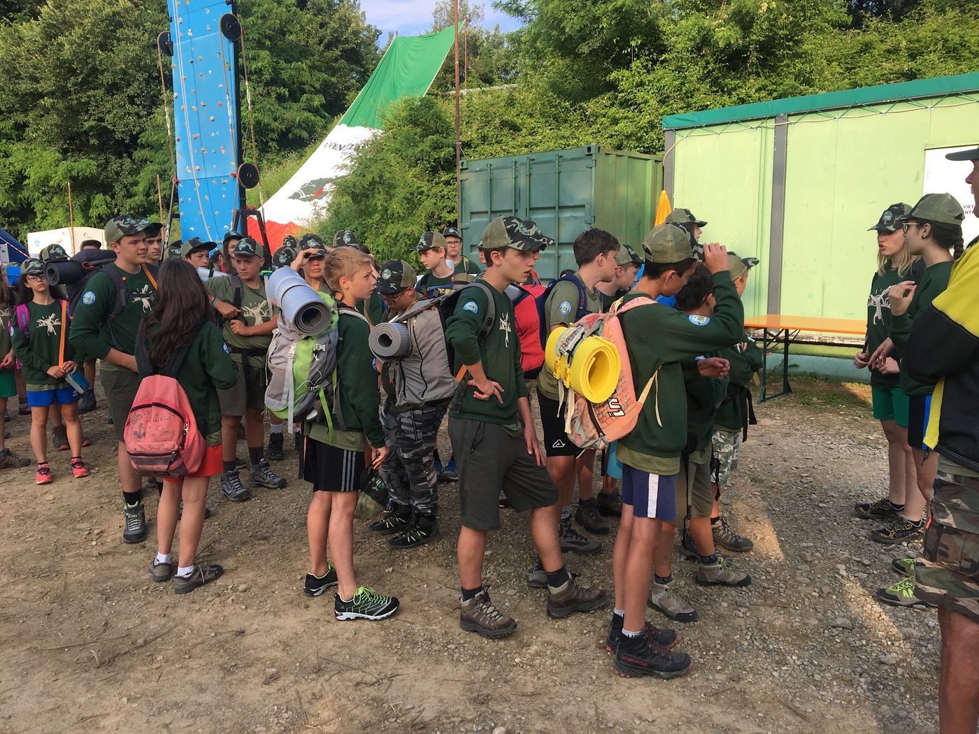 Gruppo con zaini davanti alla parete di arrampicata