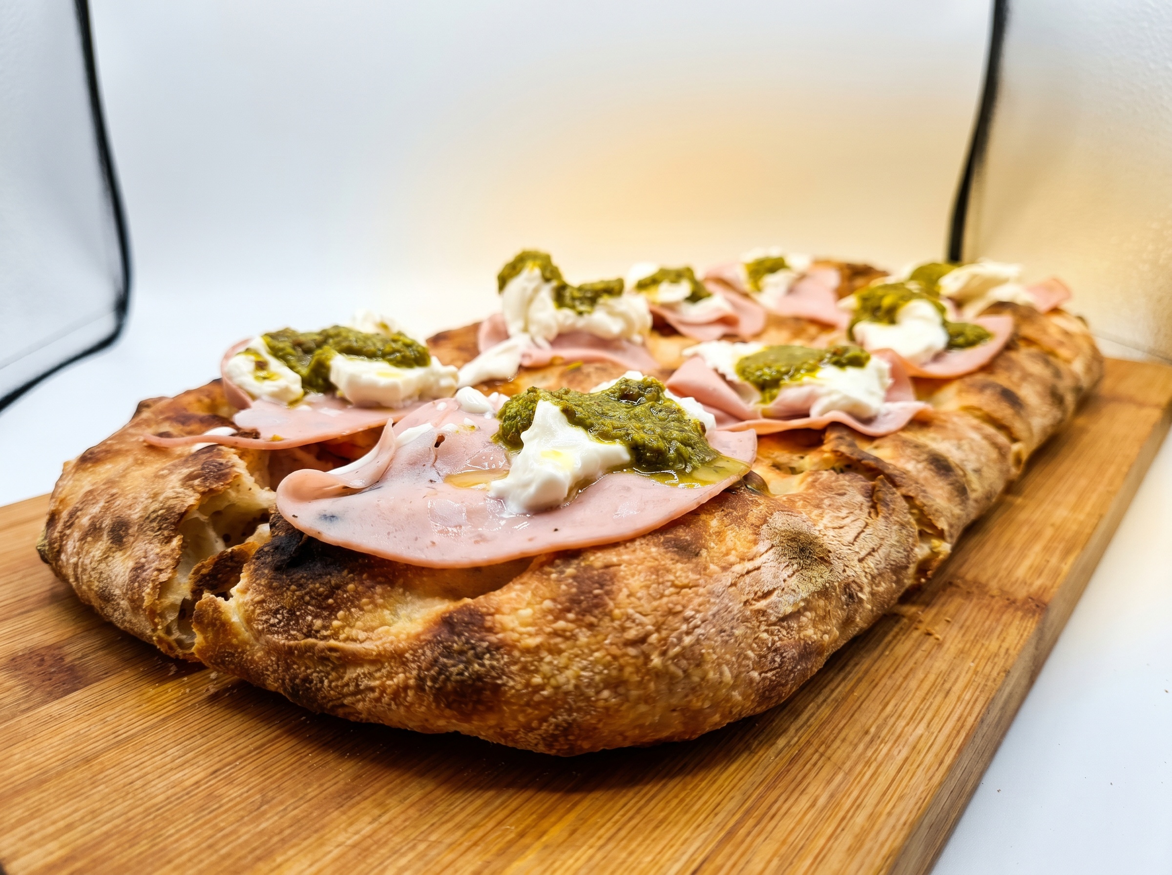 Primo piano di pizza con mortadella e pistacchio