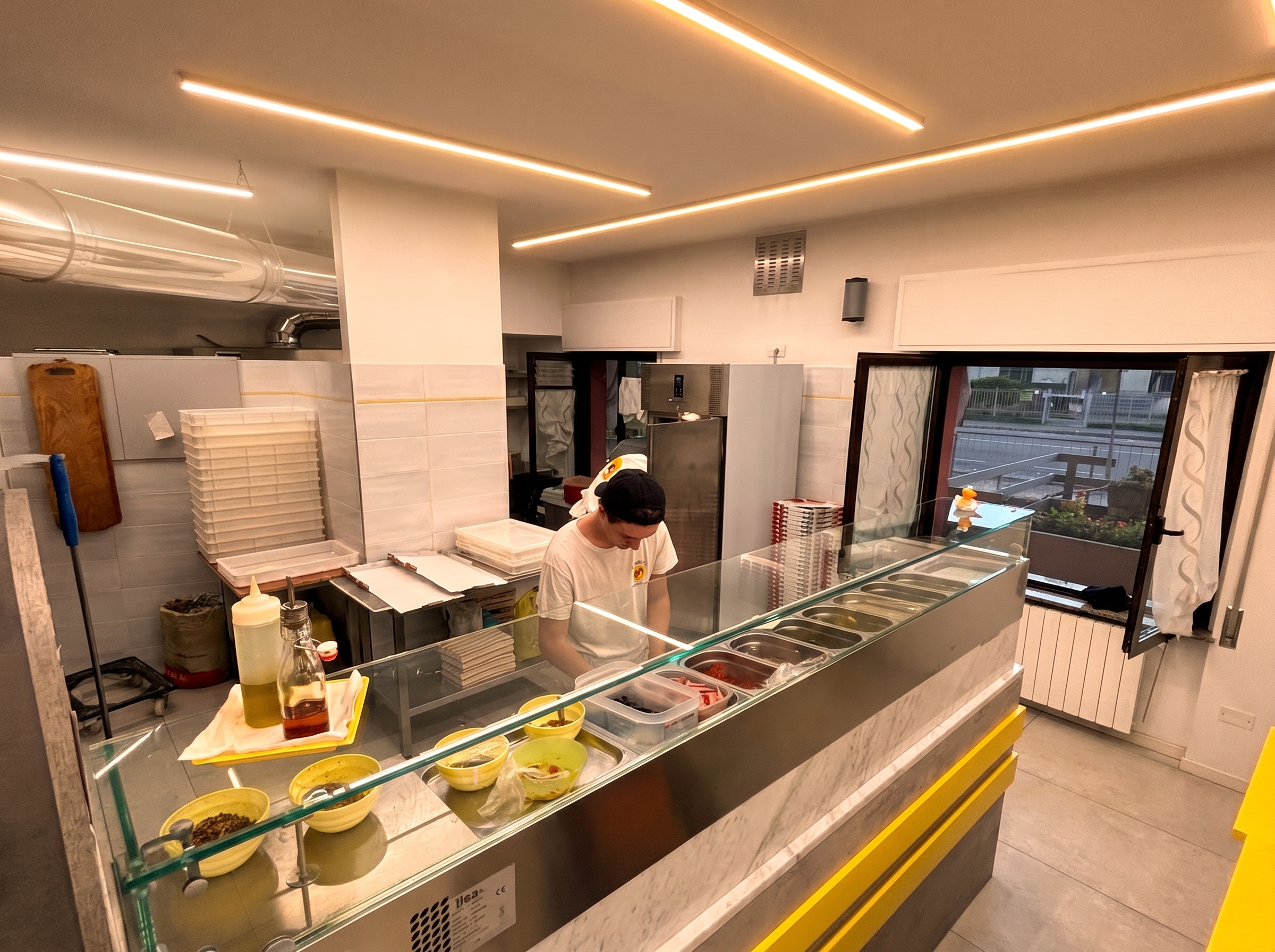 Il pizzaiolo al lavoro sul bancone
